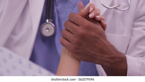 Black Doctor Holding Patient's Hand