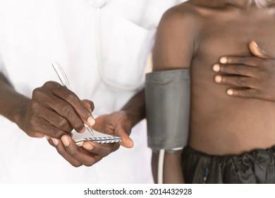 Black Doctor Measuring Blood Pressure In A Small African Boy During Routine Health Check