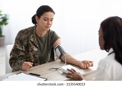 Black Doctor Woman Measuring Blood Pressure For Lady In Military Uniform, Health Care Worker Using Digital Equipment During Medical Checkup With Female Soldier, Closeup Shot With Free Space