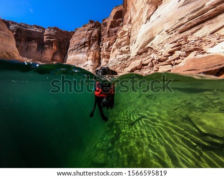 Similar – Unbekannter Jugendlicher in Neoprenanzug und Schnorchel im klaren Wasser mit felsigen Klippen von Menorca, Spanien, geteilter Blick über und unter der Wasseroberfläche