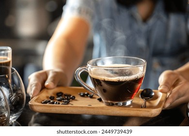 black drip coffee in glass cup, Barista making drip coffee by pouring spills hot water on coffee bean. Barista serve holding cup of hot black coffee or americano for serve on wooden table cafe shop - Powered by Shutterstock