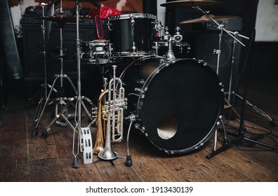 A Black Drum Kit And A Microphone Stand Are On Stage And Next To Them Are Two Trumpets (alto And Bass) And A White Tambourine. The Concept Of A Live Concert Of A Jazz Band.