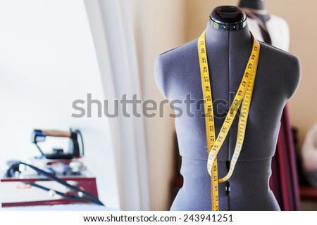 Black dummy with measuring tape in tailors studio