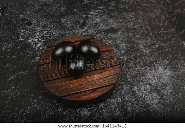 Black eggs on on a dark background. flat lay. Black\
Easter. three black eggs