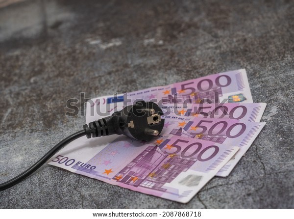 Black electric cable and 500 euro banknotes.\
expensive electricity