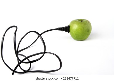Black electric cable stab in fresh green apple 