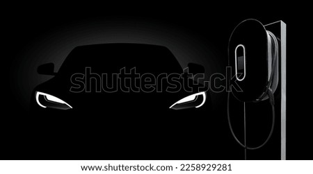 Black electric car with a charging station in the dark.
