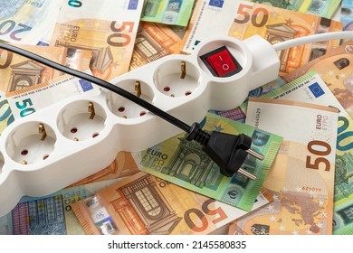 Black Electric Plug Pulled Out Of The Switched Off Power Strip Over Euro Banknotes Background. Inflation And Power Crisis. Turn Off Electric Appliances, Increasing The Energy Costs. Top View.