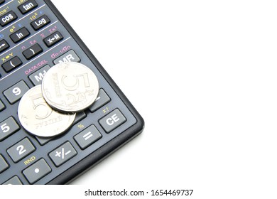 
A black engineering calculator (not completely, but part) with gray buttons and two five-ruble Russian coins lie on it. White isolated background. Accounting for finance and budget.