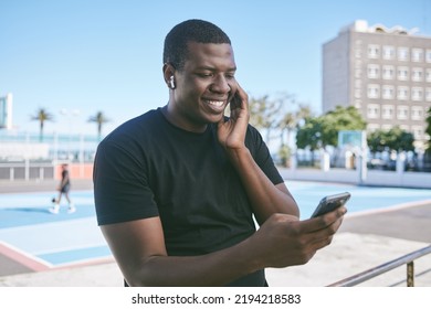 Black Entrepreneur On Social Media And Phone Listening Audio With Wireless Earphones In City Street. Ecommerce Tech, Online Shopping, Video Call Read Emails And Happy Freelance Worker Man Outdoors.