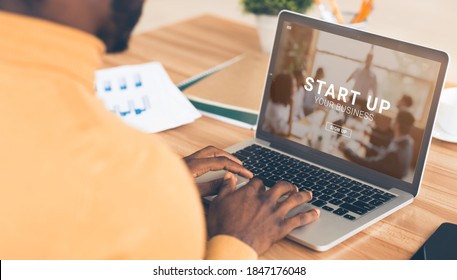 Black Entrepreneur Using Online START UP YOUR BUSINESS Platform On His Laptop, Panorama. Managing New Project Remotely, Creating Brand Website, Digital Promotion Concept