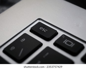 Black esc button escape close up on a laptop keyboard 