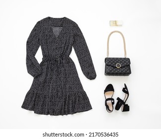 Black evening dress, small black bag with chain strap and heeled sandals on white background. Women's stylish outfit. Overhead view of woman's clothes. Flat lay, top view. - Shutterstock ID 2170536435