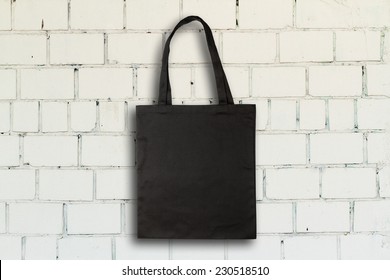 Black Fabric Bag Against Vintage Brick Wall