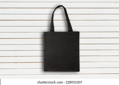 Black Fabric Bag Against White Wooden Wall