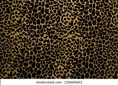 Black Fabric With Metallic Golden Leopard Fur Print. Retro Fashion Background.