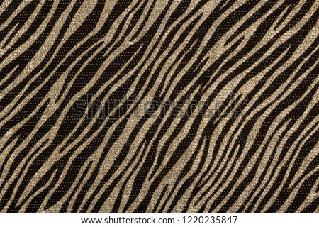Black fabric with metallic golden zebra pattern. Fashion background.