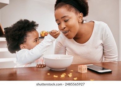 Black family, baby and feeding mother in home, food and meal for nutrition at breakfast in kitchen. Mommy, daughter and helping mom or support on weekend, love and child for morning bonding together - Powered by Shutterstock