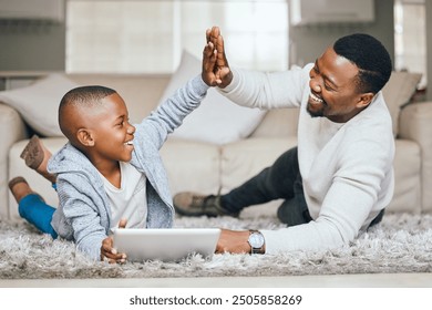 Black family, child and tablet with high five at house for streaming, education success and celebration of learning. Father, boy and digital for reading ebook, study achievement and bonding support - Powered by Shutterstock