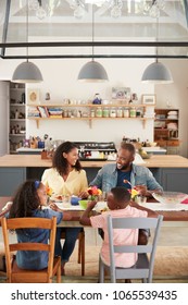 Black Family Of Four Having Lunch In Their Kitchen, Vertical