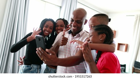 Black Family Gathering Together To Speak Through Cellphone Camera With Family