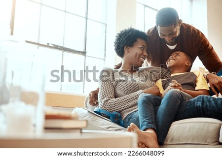 Black family, happy and relax on sofa with boy and parents, hug and laughing in their home together. Happy family, mother and father playing with their son on a couch, content and joy in living room