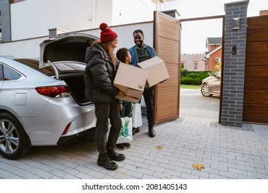 Black Family Standing On Parking With Craft Boxes During Moving Outdoors