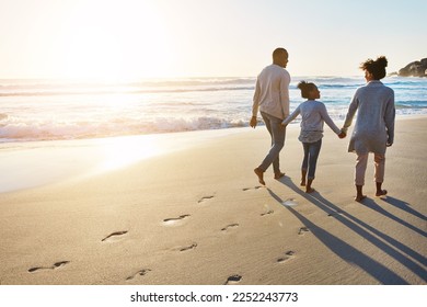 Black family, sunset and beach walk during summer on vacation relaxing at a peaceful scenery by the ocean. Sea, footprints and parents with daughter, child or kid with childhood freedom - Powered by Shutterstock