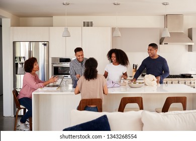 Black Family In Their Kitchen Talking And Preparing A Family Meal Together