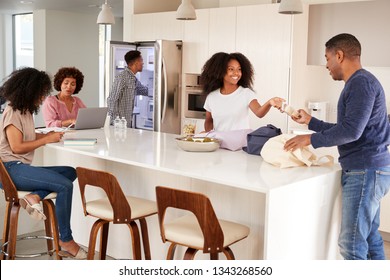 Black family unpacking groceries and spending time in their kitchen together - Powered by Shutterstock