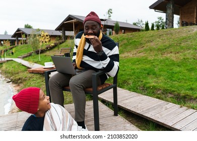 Black Family Using Gadgets And Eating Pizza While Resting Outside City