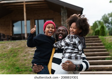 Black Father Laughing While Making Fun With His Sons While Resting Outside City