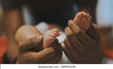 Black father playing with baby feet. Close up. High quality photo - Powered by Shutterstock