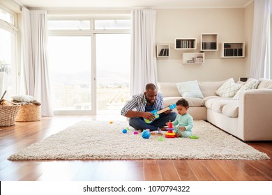 Black father and toddler son playing in the sitting room - Powered by Shutterstock