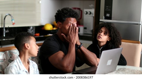 Black Father Working At Home While Children Interrupt And Complain