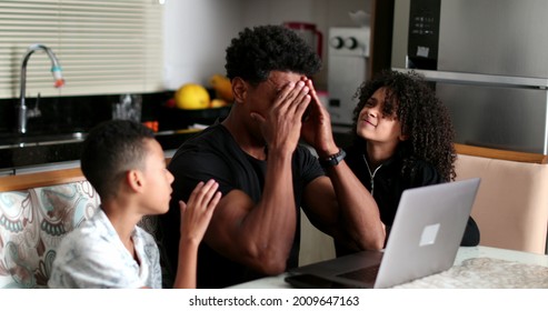 Black Father Working At Home While Children Interrupt And Complain