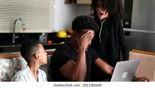 Black Father Working At Home While Children Interrupt And Complain