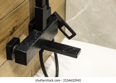 Black faucet with limescale deposits due to water hardness close-up