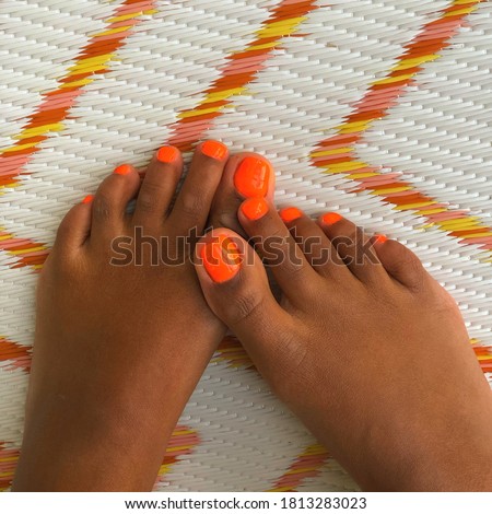 Black Feet crossed on brightly colored rug 