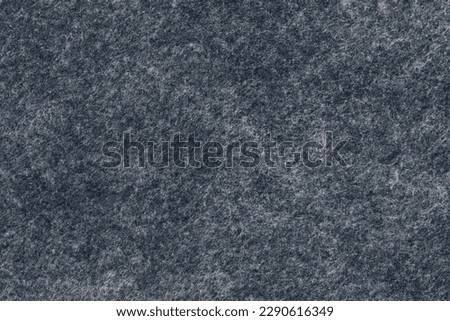 Black felt material. Surface of felted fabric texture abstract background in dark gray color. 