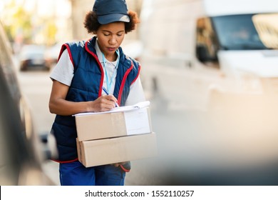 Black Female Courier Writing Down Address Stock Photo 1552110257 ...