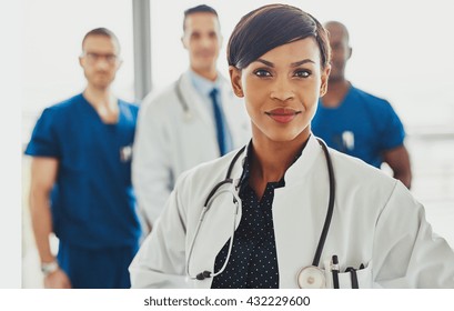 Black Female Doctor Leading Medical Team At Hospital, Stethoscope Around Neck