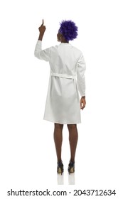 Black Female Doctor In White Lab Coat And High Heels Is Standing And Pointing Up. Rear View. Full Length Studio Shot Isolated On White.