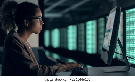 black female engineer working in server room.
