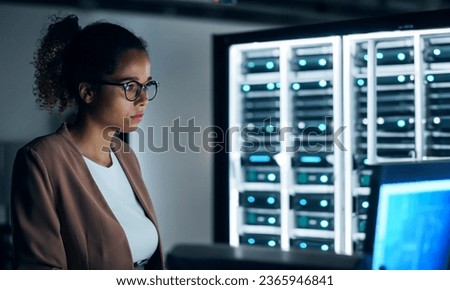 black female engineer working in server room.