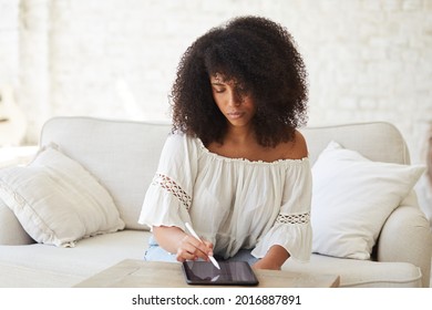 Black female freelance artist using digital tablet with electronic pencil to create crypto art or drawing illustrations. Designer working home, sketching in graphic notepad. Learning new technologies - Powered by Shutterstock