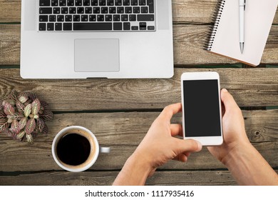 Black female hands holding smartphone with blank screen for advertisement. Top view of african-american hands, laptop keyboard, coffee, mobile on dark wooden table background, copy space - Shutterstock ID 1117935416