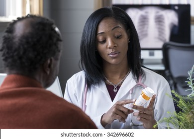 A Black Female Physician Prescribing Pills To An Older Black Male Patient