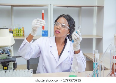 Black Female Scientist Or Doctor In Protective Glasses And Gloves Testing Tube Antivirus Ingredient In Laboratory,concept Research Sample Of Antibiotics And Vaccine In Medical Development For People