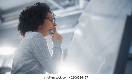 Black Female Scientist Solving Problems   Writing Complicated Math Equation the Whiteboard  Genius  Conceptuality   Breakthrough in Science   Technology Concept 
